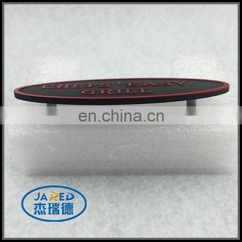 Oval badge with two hollow rivets